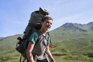Teen summer adventure camp student hiking in Alaska Mountains and Coast 